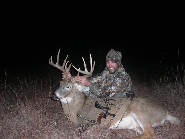 Hunting triumph with Scrape Juice attractant - A hunter celebrating his catch, highlighting Scrape Juice as the essential tool for successful hunting.